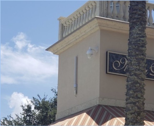 Camera and radio equipment beneath a building roofline, from the supplied case.