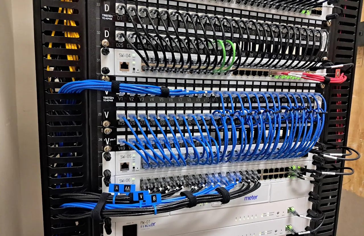 Network rack with blue patch cables dressed across patch panels and switches
