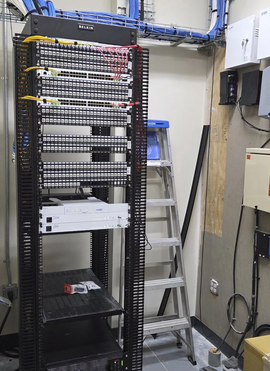 Floor-standing network rack with patch panels in an equipment room