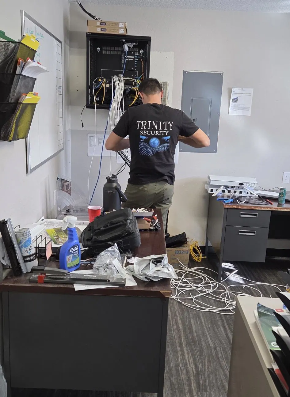 Technician in a Trinity Security shirt at an office wall panel