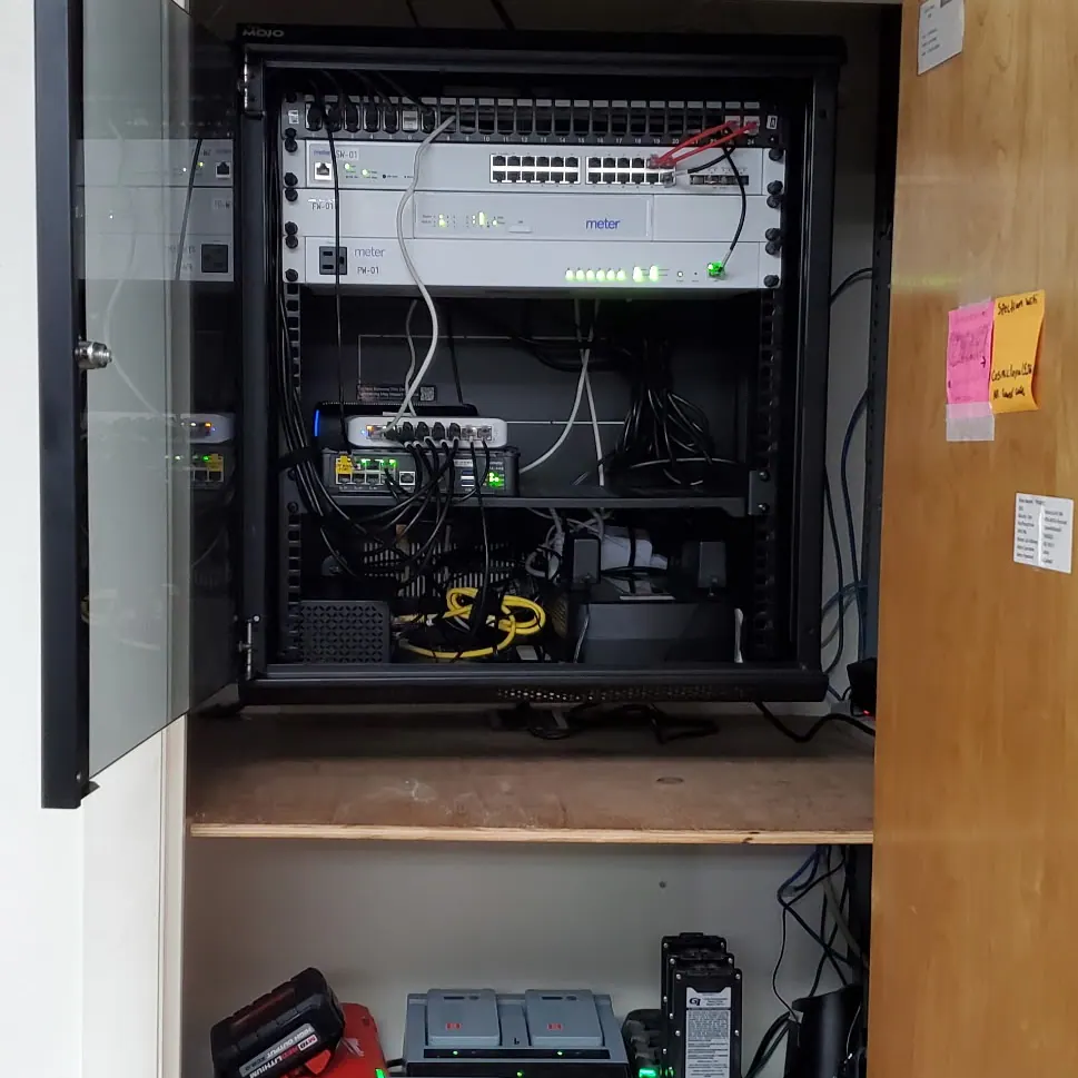 Open wall cabinet with network switches and patch panels