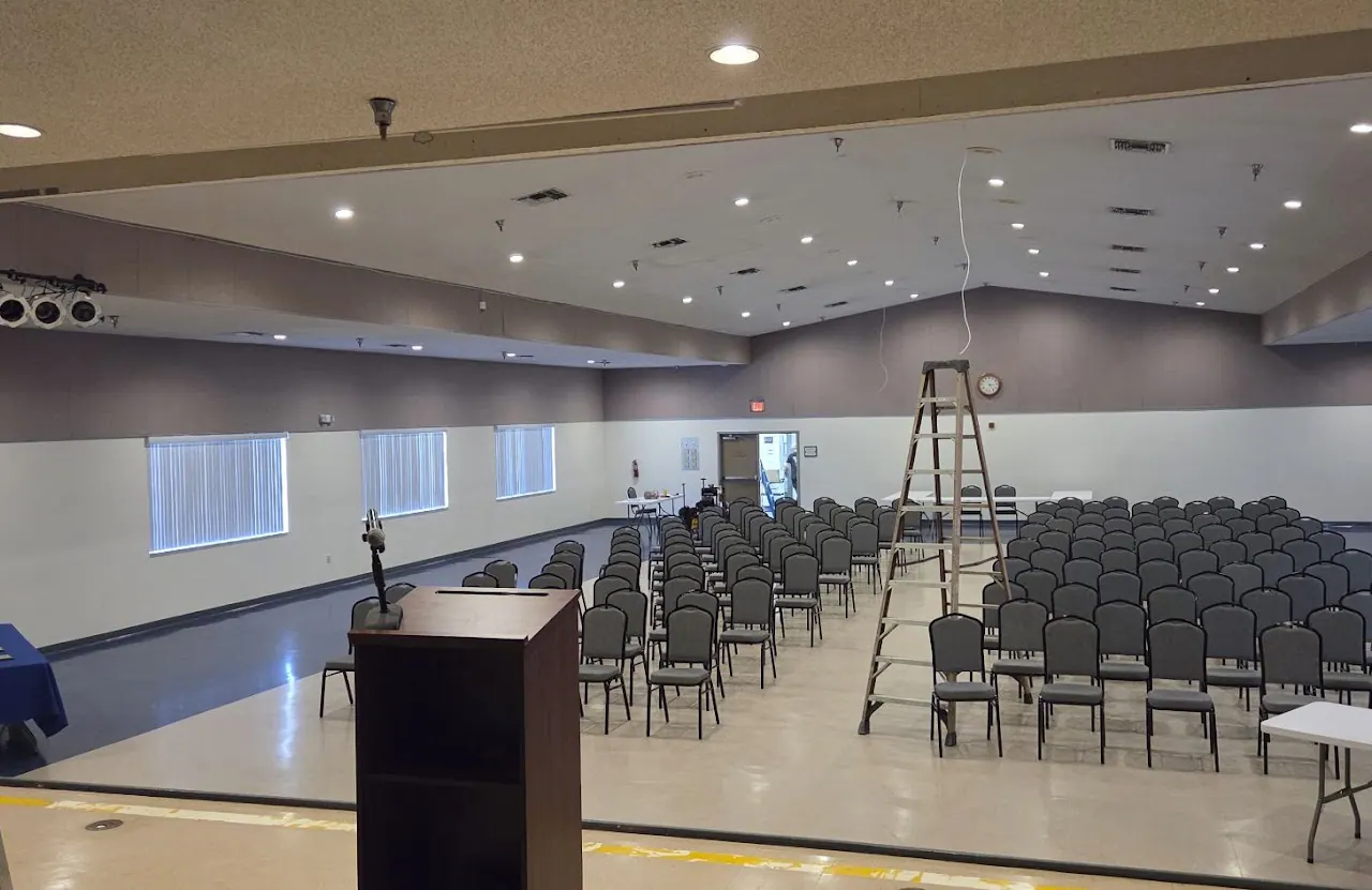 Hall with rows of chairs, a lectern and ceiling fixtures
