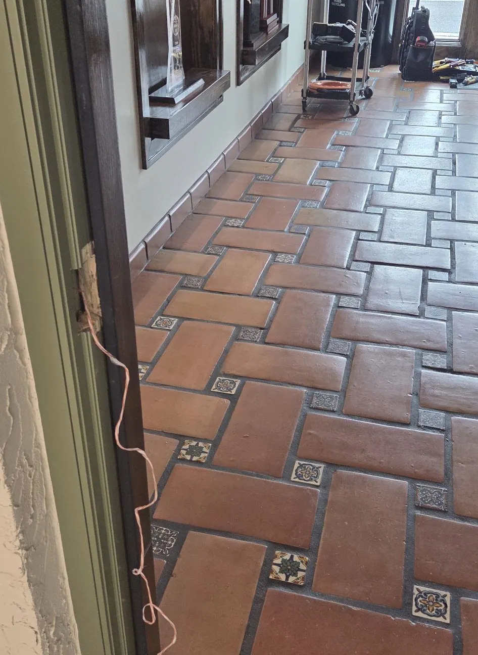 Terracotta tile floor beside a glass door in a Spanish-style building