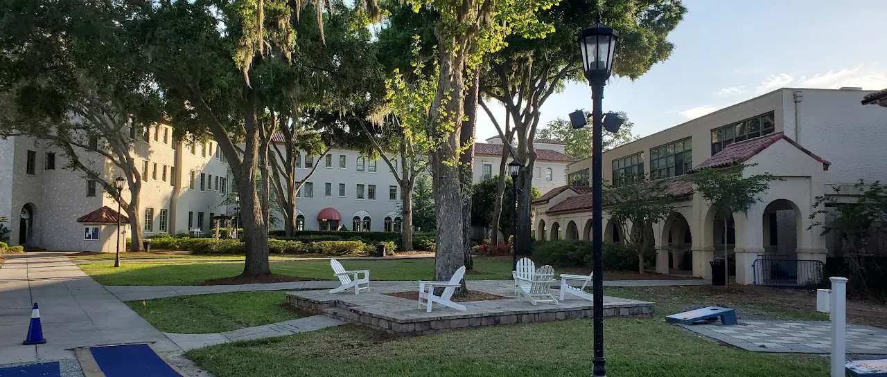 Courtyard with a lamp post, lawn chairs and cream buildings