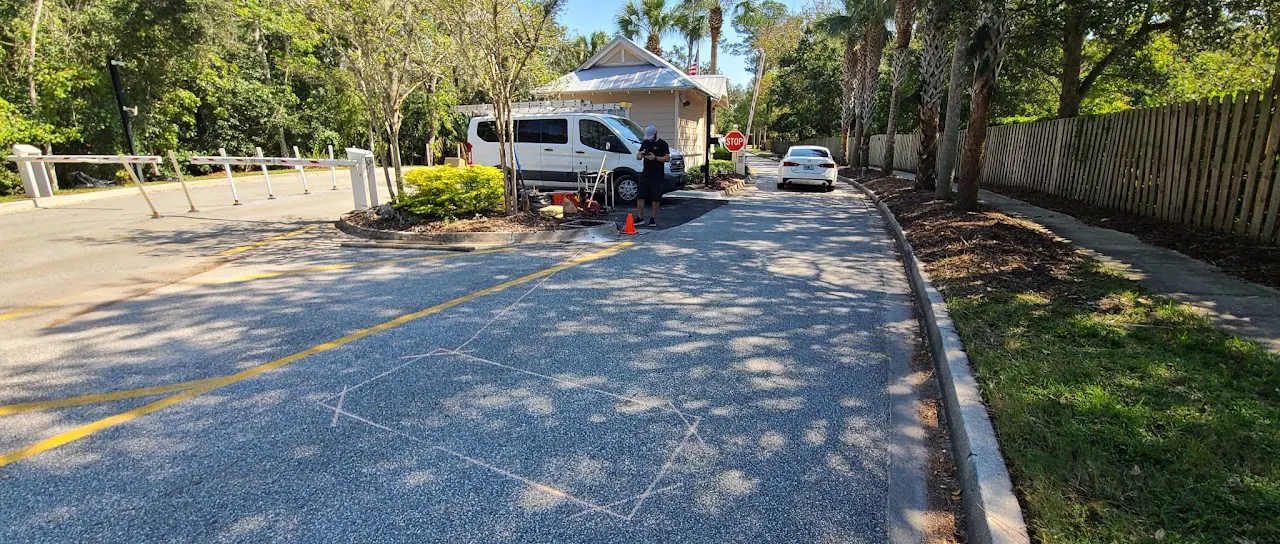 Paved driveway with a white van, trailer and bollards near a gazebo