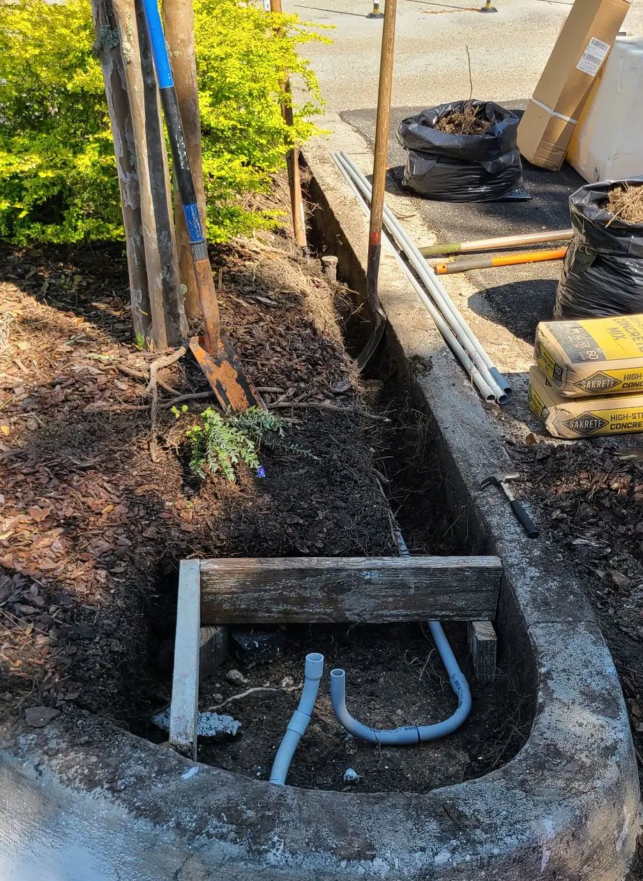 Concrete pit with a conduit bend and stone base during installation