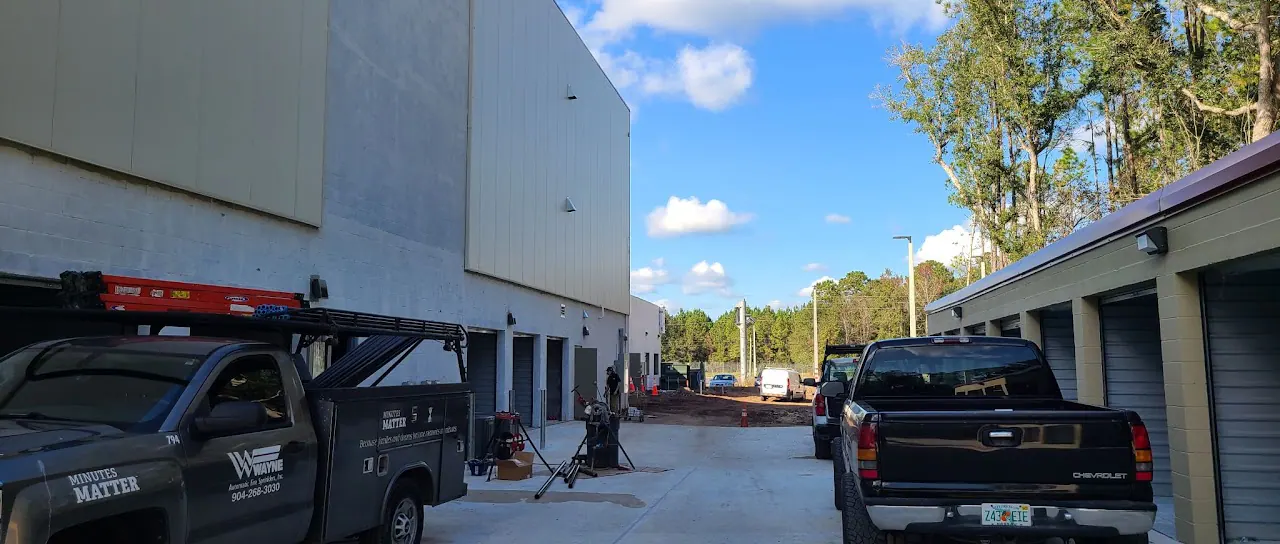Storage units and a work truck beside a driveway