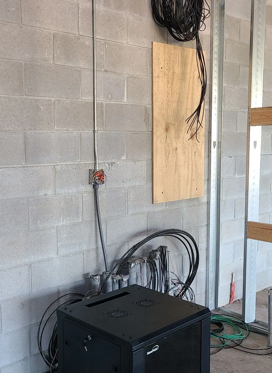 Concrete block wall with an electrical box and a black equipment enclosure