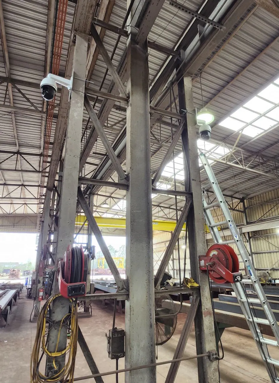Steel columns with a PTZ camera, hose reels and a ladder in a shed