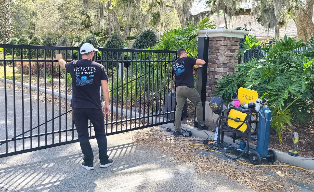 Two Trinity Security technicians working on a driveway gate